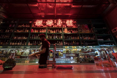 Bartenders prepare for a shift in the Ping Pong Gintoneria in central Hong Kong, which features a large neon sign above the bar. While most neon signs have disappeared from the city, some venues are o...