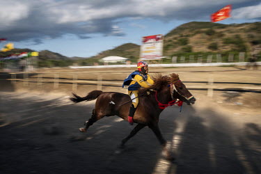 A child jockey races his mount during a preliminary round of the 'Regional Police Chief's Cup 2019'.  Racing is deeply rooted in the island's culture but the use of children, usually aged between 5-10...