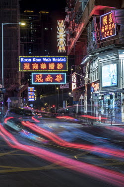 Traffic streams past the Koon Nam Wah bridal store in Yau Ma Tei. The store's neon sign is one of the few remaining that overhang streets in the traditional style.