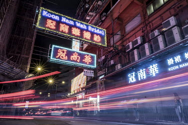 Traffic streams past the Koon Nam Wah bridal store in Yau Ma Tei. The store's neon sign is one of the few remaining that overhang streets in the traditional style.