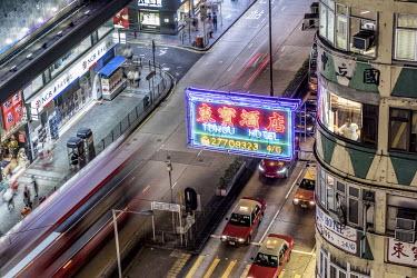 Traffic passes beneath a sign for the Tohou Hotel on Nathan Road in Kowloon. Nathan Road was once famous for its sea of competing neon lights, but in recent years these have all but disappeared, and l...