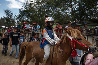 After winning a race, a child jockey and horse are led off the racetrack during preliminary stages of the 'Regional Police Chief's Cup 2019'.Racing is deeply rooted in the island's culture but the use...
