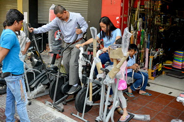 A middle class family looking at home exercise equipment at a shop on the fringes of Phnom Penh's Central Market.