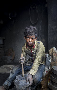 A child labourer casting metal in a workshop producing parts for the ship building industry. Child labour in Bangladesh is common, with 4.8 million or 12.6% of children aged 5 to 14 in the workforce.