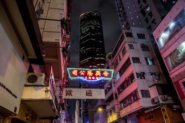 A solitary neon light illuminates a street scene in Yau Ma Tei.