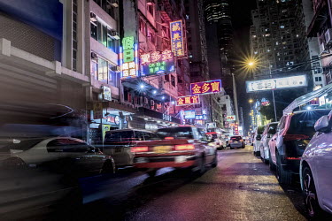 Portland street in the Mong Kok neighbourhood, glows with reflected neon lights after a rainstorm. The street is one of very few that still retain a number of neon signs.