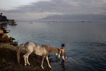 At dusk, after a day of racing in the 'Regional Police Chief Cup 2019', a boy washes a race horse in the sea, a task usually performed by former child jockeys and stable boys.   Racing is deeply roote...