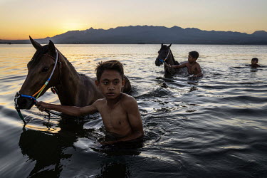 At dusk, after a day of racing in the 'Regional Police Chief Cup 2019', boys wash the race horses in the sea, a task usually performed by former child jockeys and stable boys.   Racing is deeply roote...