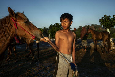 At dusk, after a day of racing in the 'Regional Police Chief Cup 2019', a boy leads a horse into the sea to wash it, a task usually performed by former child jockeys and stable boys.   Racing is deepl...