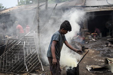 A child labourer in a metal workshop producing parts for the ship building industry. Child labour in Bangladesh is common, with 4.8 million or 12.6% of children aged 5 to 14 in the workforce.
