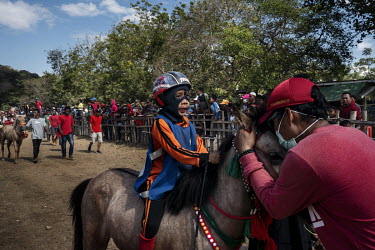 An owner embraces his horse, ridden by a child jockey, after winning his category in the final of the 'Regional Police Chief's Cup 2019'.   Racing is deeply rooted in the island's culture but the use...