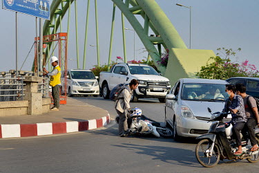 A motorscooter rider picks up his machine having just collided with a car at the entrance to the 100-hectare former wasteland of Koh Pich (Diamond Island).
