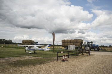 Tractors transporting bales of straw, passing the Fenland Airfield, which has a grass runway and is surrounded by agricultural land in South Holland.  In the 2016 referendum on Britain's position with...