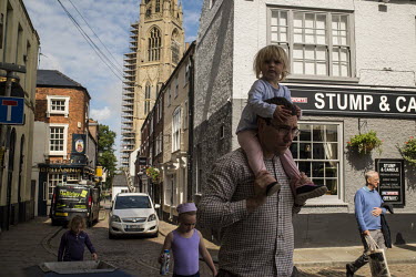 A family in the historic part of Boston with the Boston Stump rising behind.   In the 2016 referendum on Britain's position within the EU, the Boston district produced the highest pro-Brexit vote, 75....
