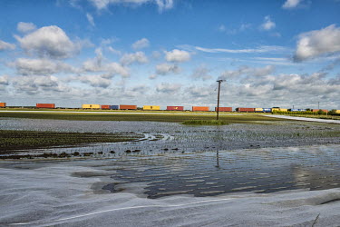 Shipping containers, being transported by train, pass by fields waterlogged after heavy rains.  In the 2016 referendum on Britain's membership of the EU, the South Holland district produced the second...