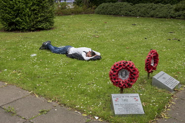 An Eastern European migrant labourer sleeps on a patch of grass at the town's war memorial. Beside him are two plinths and wreaths of poppies, memorials to World War 1 battles.  In the 2016 referendum...