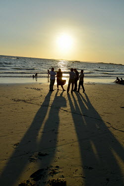 Chinese tourists on the beach at sunset.