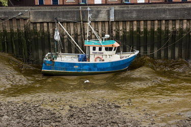 A trawler stranded on a mudbank in the Haven, the tidal river of the port of Boston.