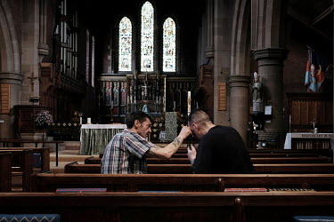 Old friends Lee and Michael talk after meeting up for the first time in years in the food bank at St Aidan's Church, run by the Rev. Gemma Sampson. Lee is pictured touching a wound that Michael sustai...