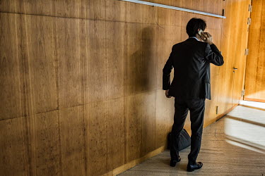 A delegate on his mobile phone before going to a meeting of the WTO General Council, the institution's highest-level decision-making body.  The World Trade Organisation has 164 members, and in theor...
