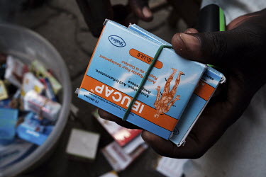 Boxes of Ibucap, labelled as containing ibuprofen, paracetamol and caffeine in the hands of an itinerant medicine peddler on a street in Lome.