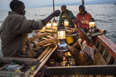 Fishermen out on Lake Mweru prepare their fishing traps which use lamps to attract small fish.  At around five o'clock in the afternoon, fishermen prepare to go out on Lake Mweru. They use floating oi...