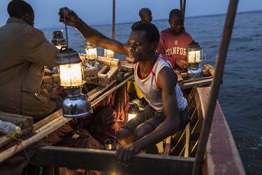 Fishermen out on Lake Mweru prepare their fishing traps which use lamps to attract small fish.  At around five o'clock in the afternoon, fishermen prepare to go out on Lake Mweru. They use floating oi...
