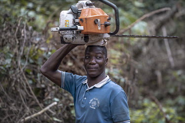 Young man with chainsaw, hired to fell trees in one of the last areas of rainforest in western Ghana. Logging companies have been granted permits to remove certain trees from the forest for the Europe...