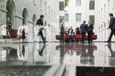Diplomats in the atrium of the WTO headquarters. This former courtyard was given a roof as part of a modernisation of the building, creating an informal meeting space.   The World Trade Organisation...