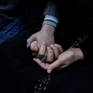 Mohammed Nour Abdullah holds his mother's hands after he returned home from a long day working in a small factory in Duztepe where he makes jeans. He works a 72 hour week, 12 hours a day, Monday to Sa...