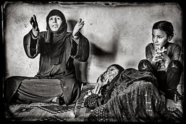 Suria (43) with the daughter (14) of her brother and her grandmother who is sick and cannot walk.  Suria's house was bombed during the conflict with ISIS. Her mother died of a heart attack during th...