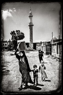 A family looking for drinking water as the water supply infrastructure was destroyed by air strikes.
