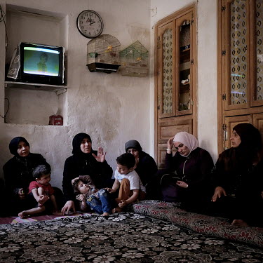 A meeting, held in a volunteer's home, of the charity Zenobia. Amina Dabko (42, speaking, centre) said that she felt she had no choice but to marry off her eldest daughter at 14. Many women described...
