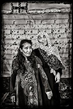 Fatima (27, L), who suffers from trauma following the constant bombing in her neighbourhood, with her sister Gedija (43) who has a bullet wound to her eye after being shot by an ISIS militant.