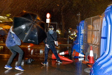 Umbrella wielding protestors close-in on government buildings as police use water canons to disburse them at the end of an event to commemorate the 5th Anniversary of the start of the 2014 'Umbrella R...