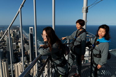 A group of Chinese tourists on a bus tour, make the 270m SkyPoint Climb up the Q1 building.