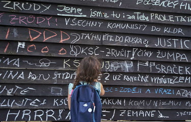 A girl reads messages written by demonstrators on a fence near the headquarters of the Communist party of Bohemia and Moravia (KSCM). The messages relate to the anniversaries of the 21 August 1968 So...