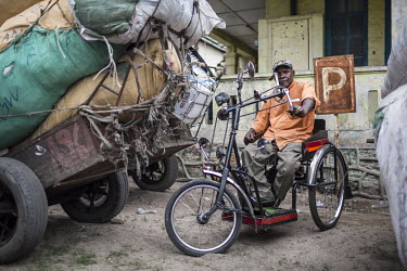 A disabled man with a hand powered tricycle parked among the carts loaded with imported goods at Onatra port. As disabled people pay less import fees savvy traders use them to import cargo cheaply fro...