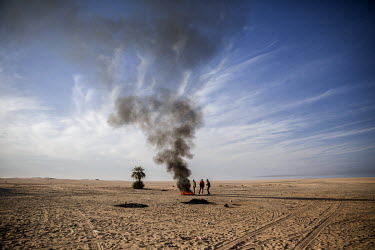 A group of migrants burning tyres to attract attention but also to try and keep warm during the desert's cold night. Their vehicle broke down while they were trying to cross the Tenere, a region of th...