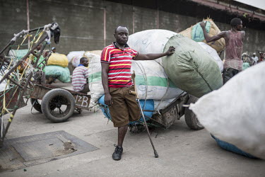 A disabled man with sacks of imported goods at Onatra port. As disabled people pay less import fees savvy traders use them to import cargo cheaply from Congo Brazzaville. As soon as the goods leave th...