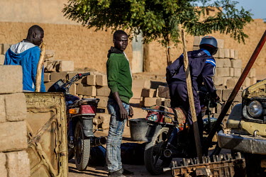 A so called 'coxeur' (people trafficker) stands next to his motorcycle near the bus station in Agadez. From the bus station he takes migrants who arrive from outside of Niger to the suburbs of Agadez...