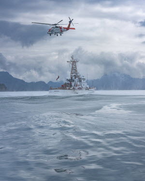 The coastguard boat Mustang, whose base is at Seward, conducts a search and rescue exercise with a helicopter, USCG Jay Haw, in Prince William Sound.