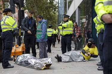 Police stand beside people, taking part in non-violent direct action during Extinction Rebellion protests, lying on the pavement outside the DEFRA offices on Marsham Street in Westminster.