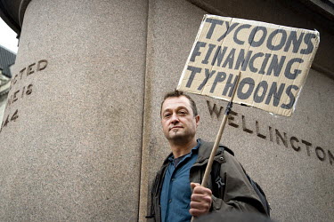 A man holding a sign during an Extinction Rebellion protest in Bank highlighting the impact that the financial sector's investment in fossil fuels, intensive farming and logging is having upon the env...