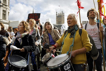 A group of female protestors playing drums as a Extinction Rebellion demonstration marches near Parliament Square.