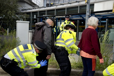 Police search activists arrested after carrying out non-violent direct action during an Extinction Rebellion protest at London City Airport.