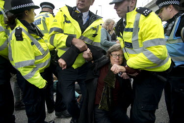 Police drag away an activist arrested after carrying out non-violent direct action during an Extinction Rebellion protest at London City Airport.