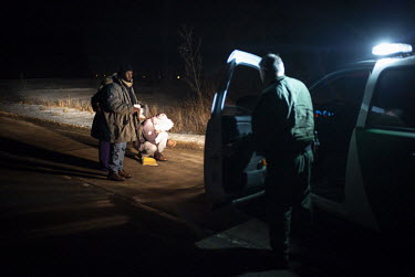 Asylum seekers Abdullahi Warsame (L), Lul Abdi Ali and Delmar Xasan, all from Somalia, are detained by a U.S. Customs and Border Protection officer. The three were eventually released after several ho...