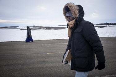 Asylum seekers, Lul Abdi Ali (L) and Delmar Xasan, from Somalia, walk north toward Canada. Xasan says that Al Shabaab attacked him and murdered his brother before he decided to flee Somalia.