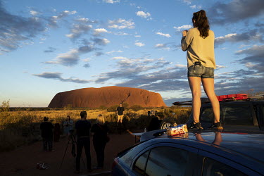 Tourist take photos of Uluru from the car sunset viewing area.   Tourists are rushing to climb world heritage-listed Monolith, Uluru in Australia's central desert before a ban on climbers takes effe...